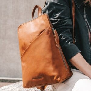 The Chesterfield Amanda Cognac Þessi svarti Chesterfield bakpoki Amanda er úr ekta Wax Pull-up leðri. Vax uppdráttarleður einkennist af mjúkri tilfinningu og tvítóna litaáhrifum. Auðvelt er að meðhöndla leðrið með mjúkum klút. Sérstök vaxmeðferðin mun hjálpa til við að endurheimta leðrið í upprunalegt útlit. Taskan þín mun líta út eins og ný alla ævi! Leðurbakpokinn Amanda er með fallegum rennilás að ofan og er með 1 rennilásvasa að framan. Innan í þessum leðurbakpoka finnur þú 4 rennilásahólf og 2 önnur hólf. Ennfremur er þessi leðurbakpoki með þægilegum vasa til að geyma snjallsímann þinn.