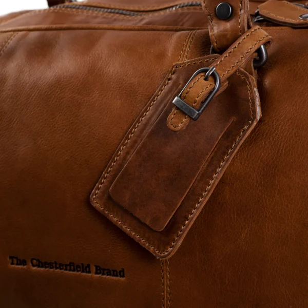 The Chesterfield William Leður Helgartaska. Ertur að fara í burtu um helgina? Þá er THE CHESTERFIELD leðurhelgartaskan okkar William fullkomin fyrir þig! Þessi rúmgóða helgartaska býður upp á nóg geymslupláss fyrir allt dótið þitt og er líka stílhrein og flott. Þessi glæsilega helgartaska er mjög hentug til að nota sem íþróttatösku,og í helgarfríið.Þessi helgartaska úr leðri hefur stórt aðalhólf (43 lítrar) með auka renndum vasa að innan. Aðalhólfið lokast með fallegum og sléttum rennilás. Þessi helgartaska kemur með langri og stillanlegri axlaról. Handföngin eru extra breið og því þægileg í hendinni. Þú getur auðveldlega viðhaldið þessari tösku með leðurvaxinu okkar, þetta er hreinsi- og viðhaldsvara í einu.
