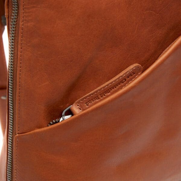 The Chesterfield Amanda Cognac Þessi svarti Chesterfield bakpoki Amanda er úr ekta Wax Pull-up leðri. Vax uppdráttarleður einkennist af mjúkri tilfinningu og tvítóna litaáhrifum. Auðvelt er að meðhöndla leðrið með mjúkum klút. Sérstök vaxmeðferðin mun hjálpa til við að endurheimta leðrið í upprunalegt útlit. Taskan þín mun líta út eins og ný alla ævi! Leðurbakpokinn Amanda er með fallegum rennilás að ofan og er með 1 rennilásvasa að framan. Innan í þessum leðurbakpoka finnur þú 4 rennilásahólf og 2 önnur hólf. Ennfremur er þessi leðurbakpoki með þægilegum vasa til að geyma snjallsímann þinn.