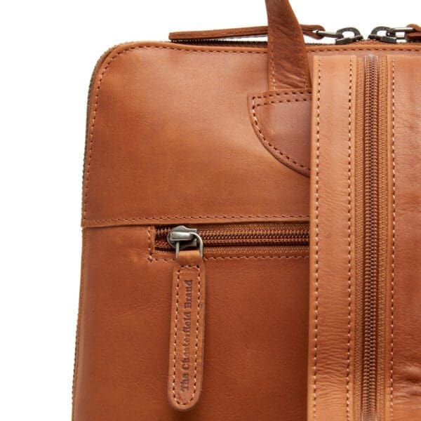 The Chesterfield Amanda Cognac Þessi svarti Chesterfield bakpoki Amanda er úr ekta Wax Pull-up leðri. Vax uppdráttarleður einkennist af mjúkri tilfinningu og tvítóna litaáhrifum. Auðvelt er að meðhöndla leðrið með mjúkum klút. Sérstök vaxmeðferðin mun hjálpa til við að endurheimta leðrið í upprunalegt útlit. Taskan þín mun líta út eins og ný alla ævi! Leðurbakpokinn Amanda er með fallegum rennilás að ofan og er með 1 rennilásvasa að framan. Innan í þessum leðurbakpoka finnur þú 4 rennilásahólf og 2 önnur hólf. Ennfremur er þessi leðurbakpoki með þægilegum vasa til að geyma snjallsímann þinn.