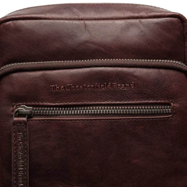 The Chesterfield Arenas Hagnýt leðurtaska til daglegrar notkunar er enginn lúxus. Með Arenas ertu kominn á réttan stað! Fullkomið til daglegrar notkunar til að bera allar nauðsynlegar nauðsynjar. Með töskunni fylgir stillanleg axlaról. Þetta gerir þér kleift að klæðast töskunni í hvaða lengd sem þú vilt. Aðalhólf töskunnar er með rennilás. Þetta hólf býður upp á nóg pláss fyrir það sem þú mátt ekki missa af; síma, lykla, (sól)gleraugu og veski. Inni í aðalhólfinu er auka geymsluhólf með rennilás og vasa fyrir símann þinn. Að framan eru tveir vasar með rennilás. Hér getur þú örugglega geymt smærri hluti og passað að missa þá ekki. Einnig á bakinu er vasi með rennilás til að geyma smáhluti.